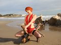 Lyza la rouquine qui strip en body sexy rouge sur la plage