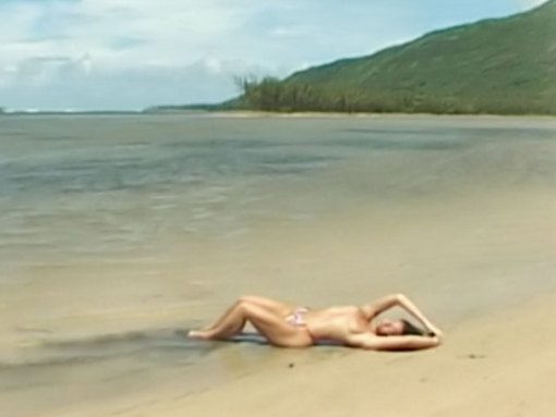Emmanuelle caresse son corps sur une plage déserte